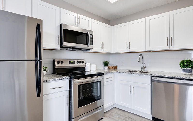 View of kitchen with modern cabinetry and white brick backsplash